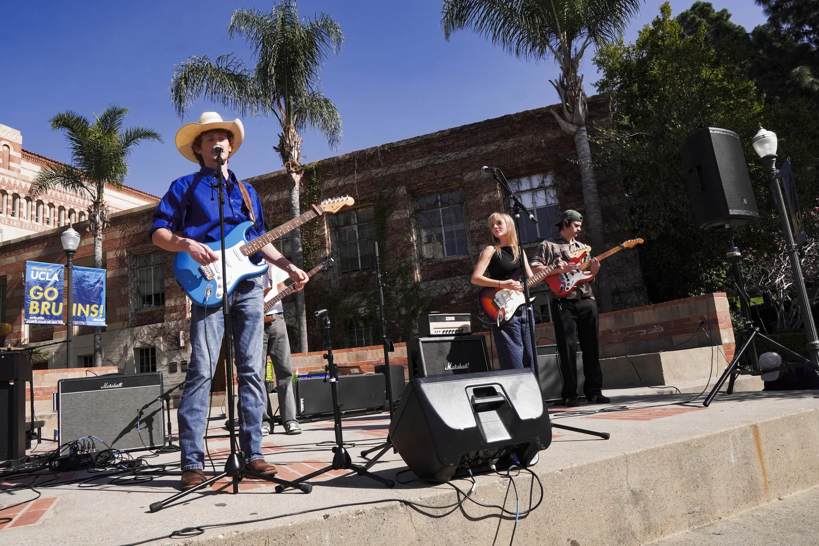Miles and South of Sober playing outdoors at UCLA beneath palm trees